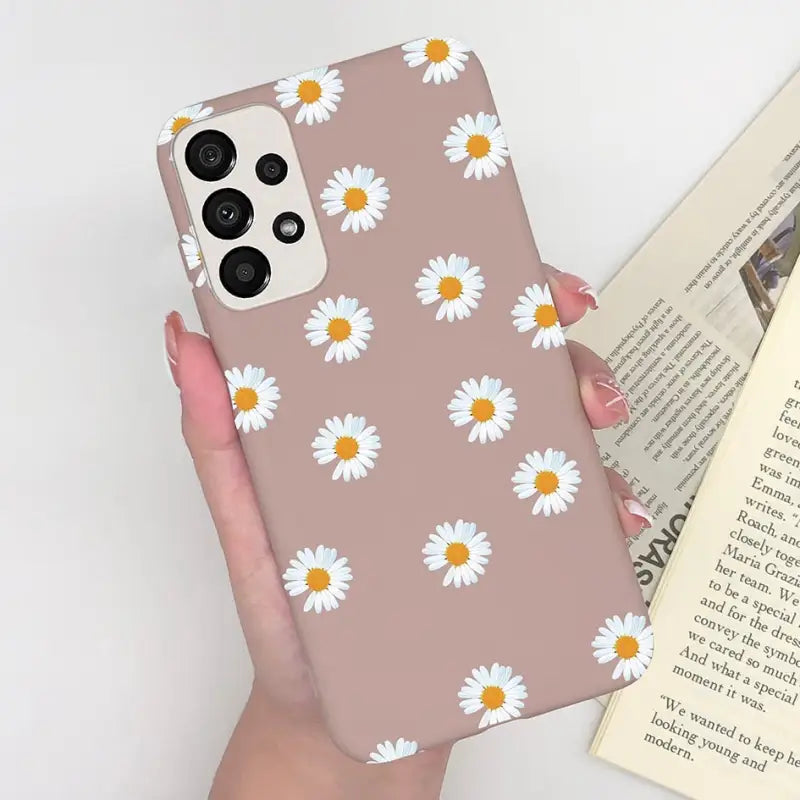 someone holding a phone case with a daisy pattern on it