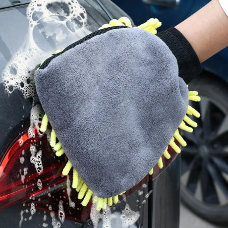 a close up of a person washing a car with a sponge