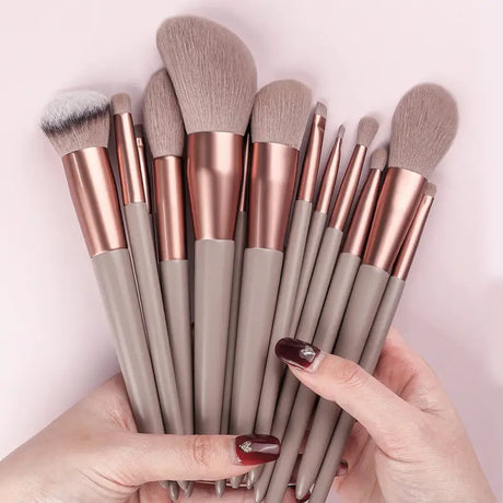 a woman holding a set of makeup brushes