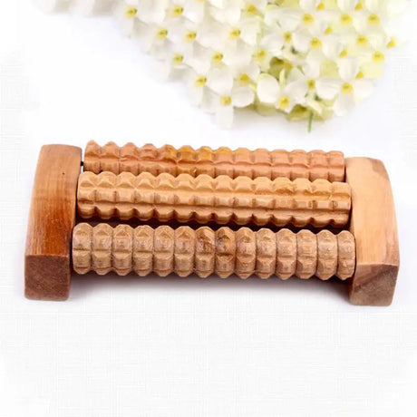 there is a wooden roller with a wooden handle next to a flower