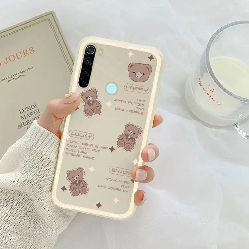 a woman holding a phone case with a bear design