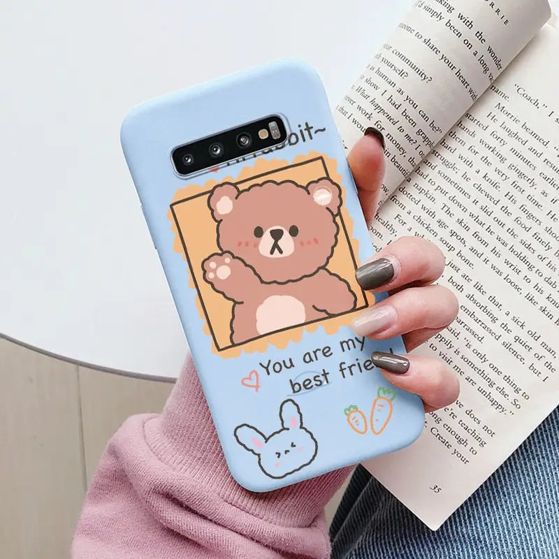 a woman holding a phone case with a bear on it