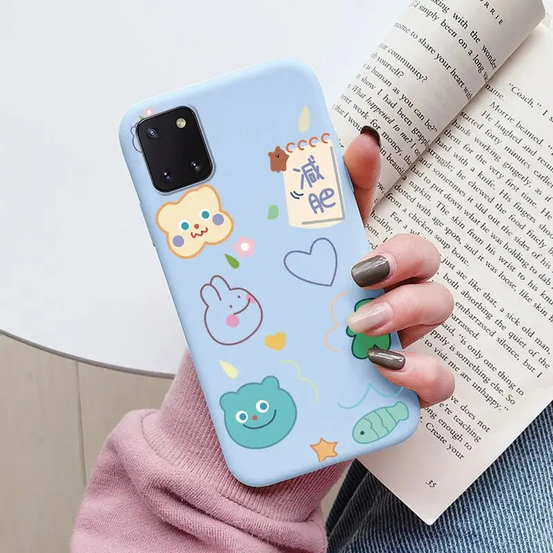 a woman holding a phone case with a pattern of animals and fish