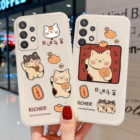 a woman holding two iphone cases with cartoon cats on them