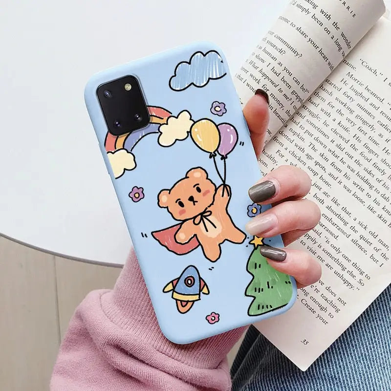 a woman holding a book and a phone case