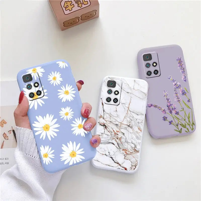 a woman holding a phone case with flowers on it
