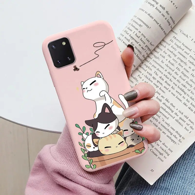 a woman holding a phone case with a cat on it
