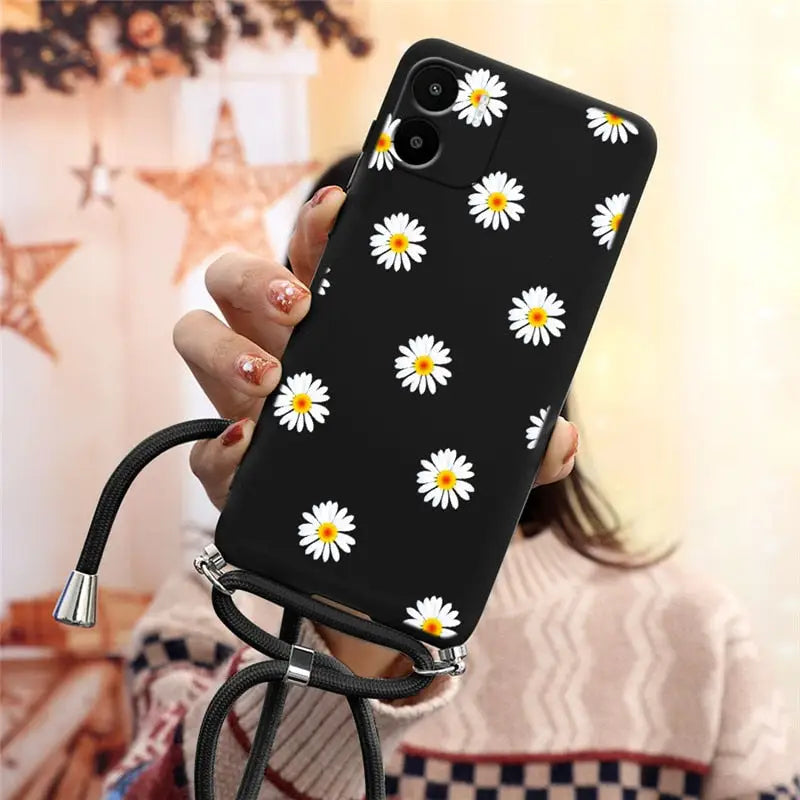 there is a woman holding a phone with a daisy pattern on it