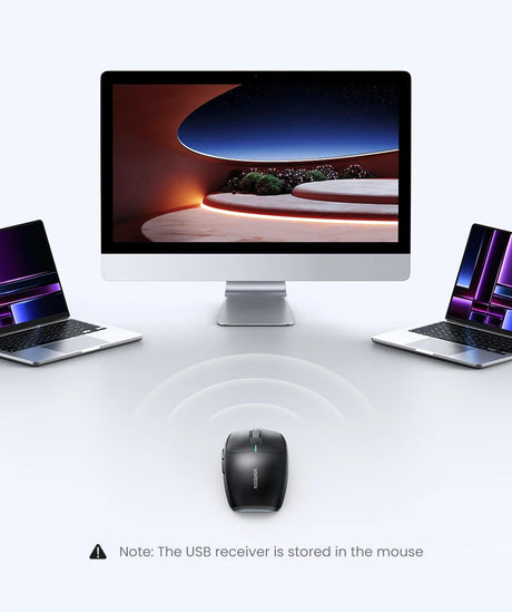 Desktop computer with a large screen flanked by two laptops and a wireless mouse in front.