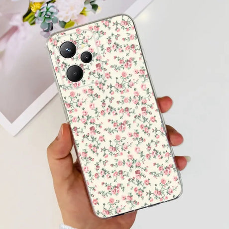 a woman holding a phone case with pink flowers on it