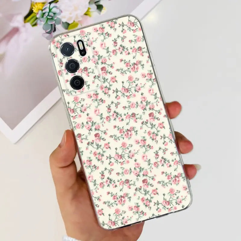 a woman holding a phone case with a floral pattern