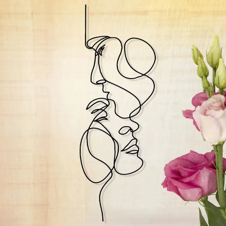 a vase with flowers and a wire sculpture