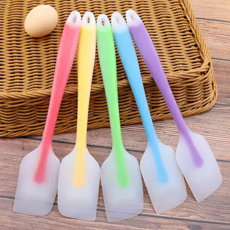 four plastic spats with handles and a plastic spoon with a plastic handle