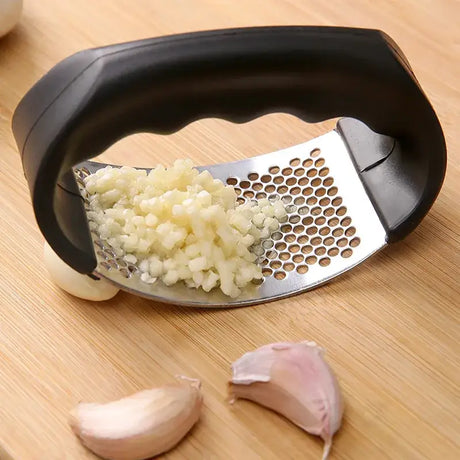 a garlic cutter with onions on a cutting board