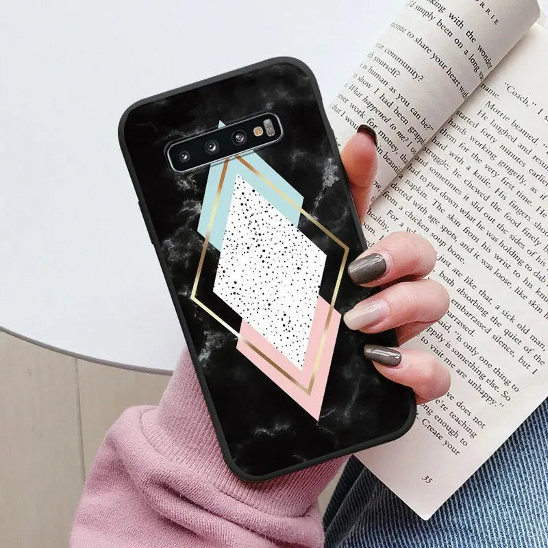 a woman holding a phone case with a geometric design