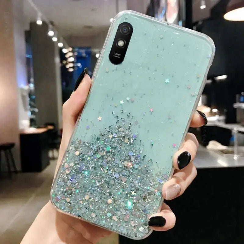 a woman holding a phone case with glitter on it