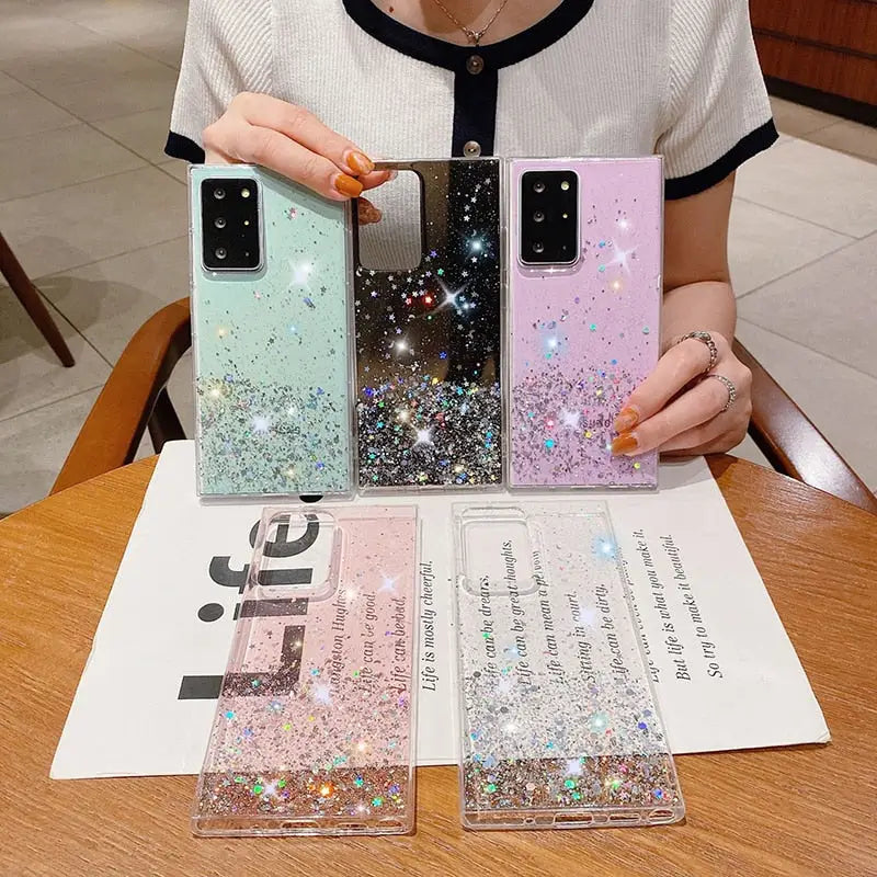 a woman holding a phone case with glitter