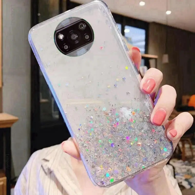 a woman holding a phone case with glitter