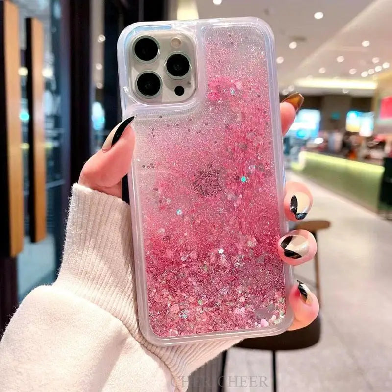 a woman holding a pink glitter phone case