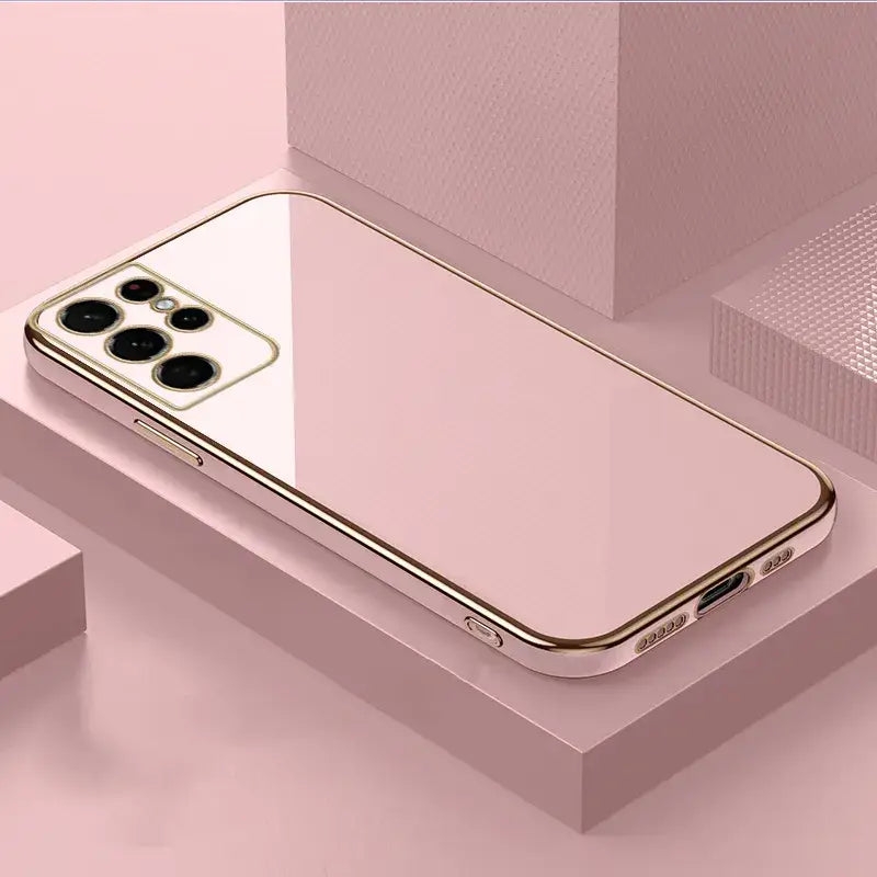 A gold iphone case on a pink background