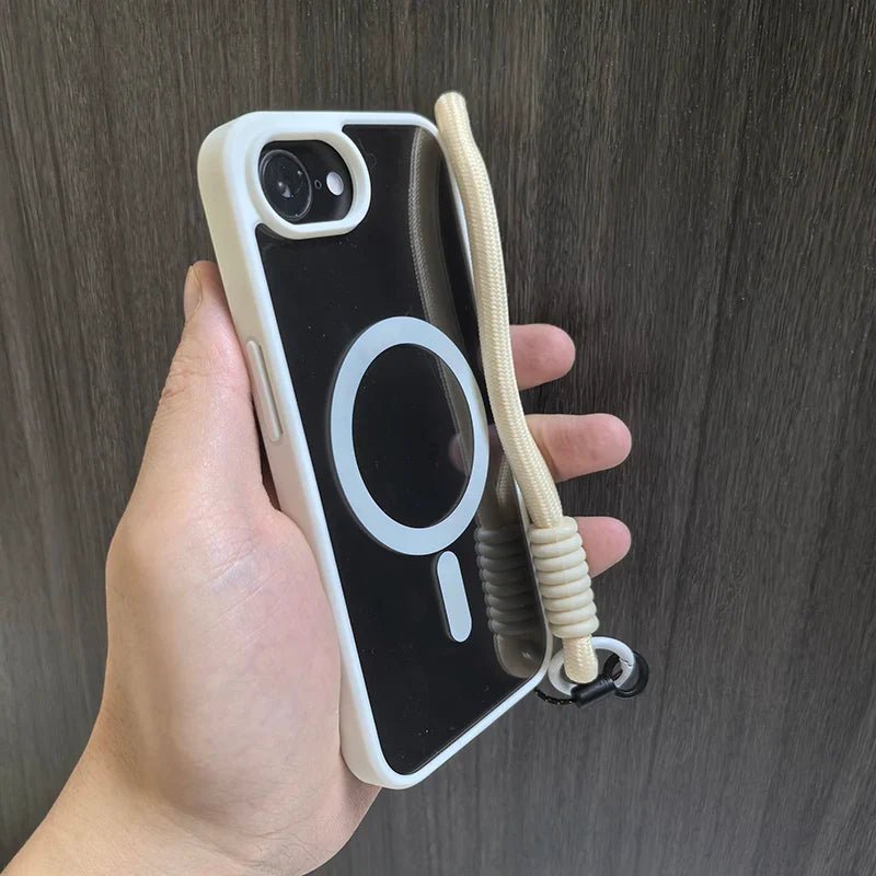 Hand holding a black phone case with a white MagSafe ring and a beige wrist strap.