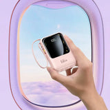 a hand holding a phone in front of an airplane window