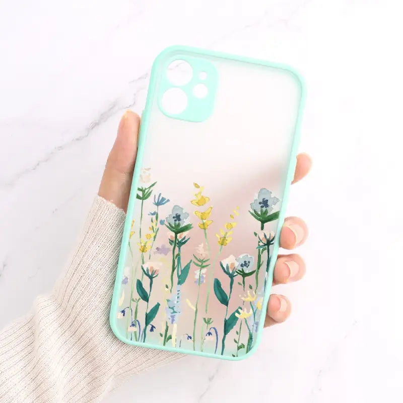 A hand holding a phone case with flowers on it