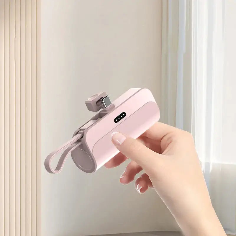 a hand holding a pink phone with a camera attached to it