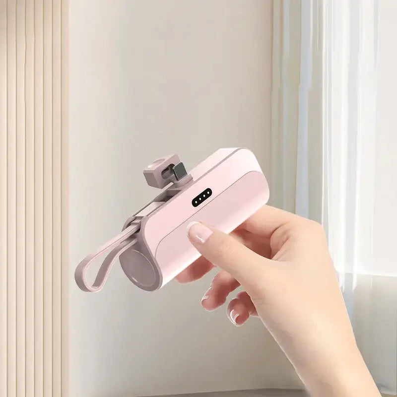a hand holding a pink smart phone with a camera attached to it