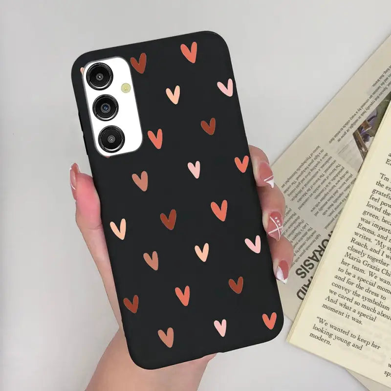 a woman holding a phone case with hearts on it