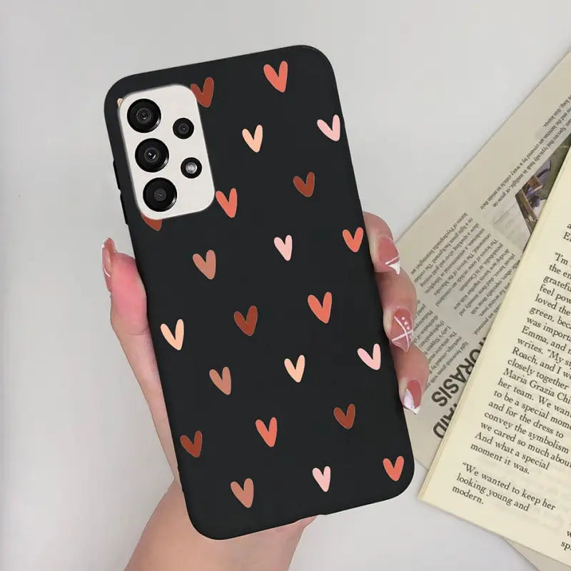 a woman holding a phone case with hearts on it