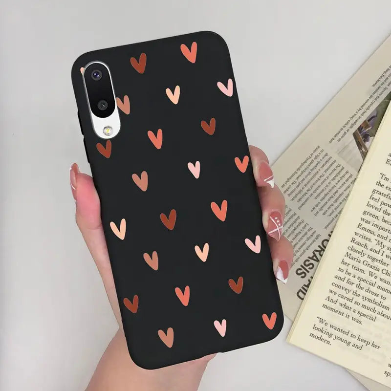 a woman holding a phone case with hearts on it