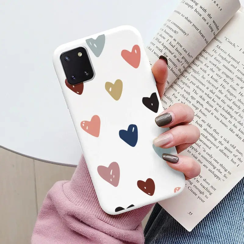 a woman holding a book and holding a phone case