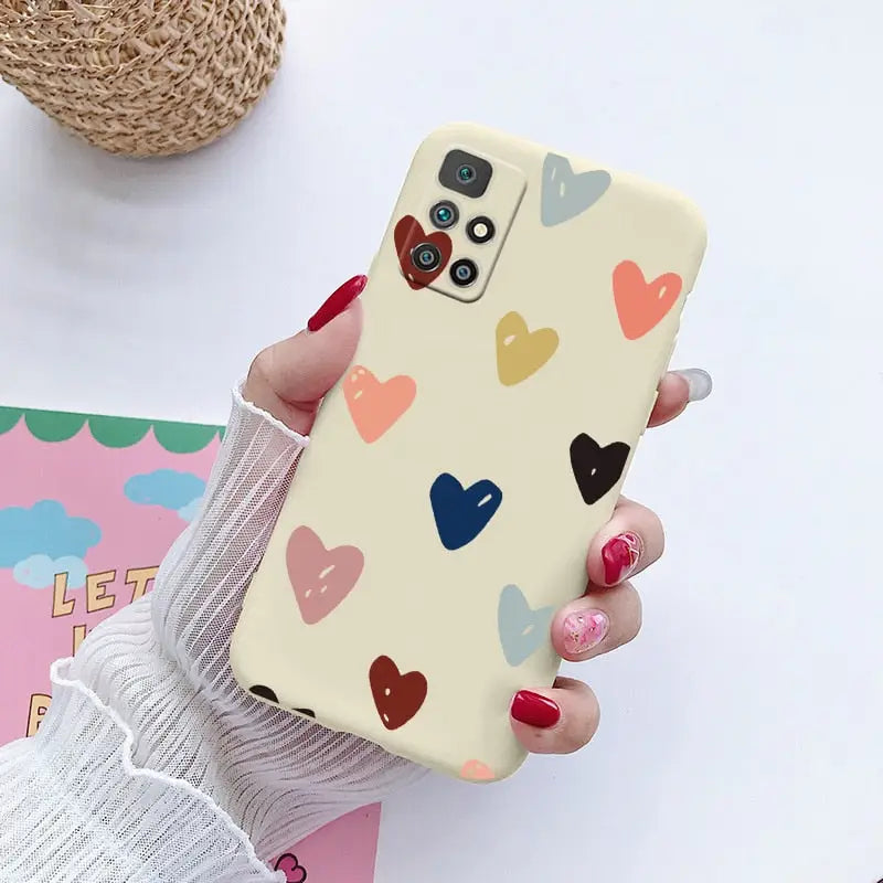 a woman holding a phone case with hearts on it
