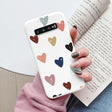 a woman holding a book and holding a phone case