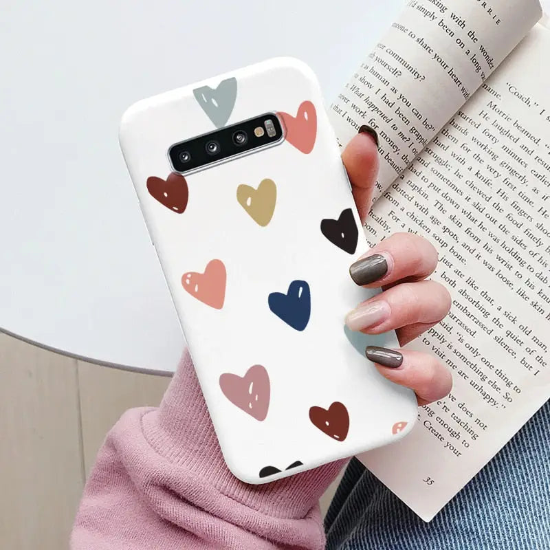 a woman holding a book and holding a phone case