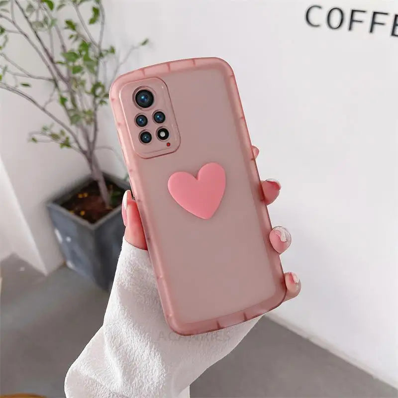 a woman holding a pink heart phone case