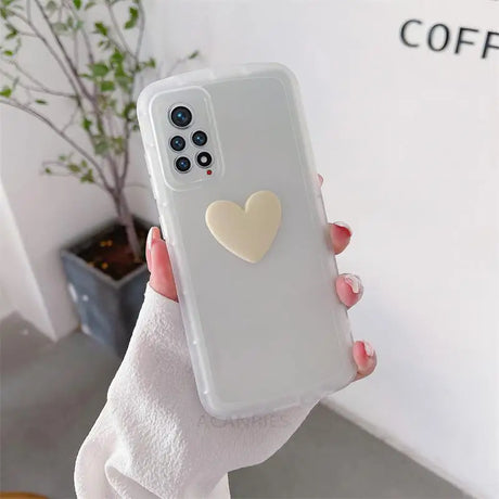 a woman holding a white phone case with a heart on it