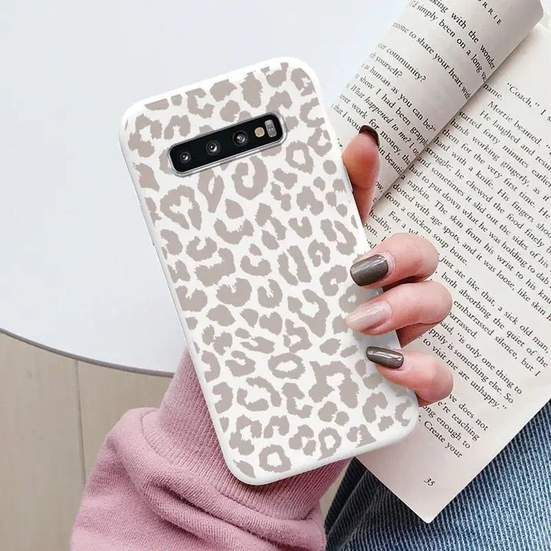 a woman holding a book and a phone case