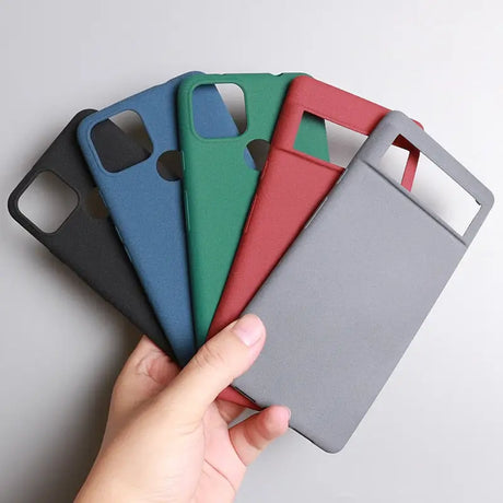 a hand holding a phone case with four different colors
