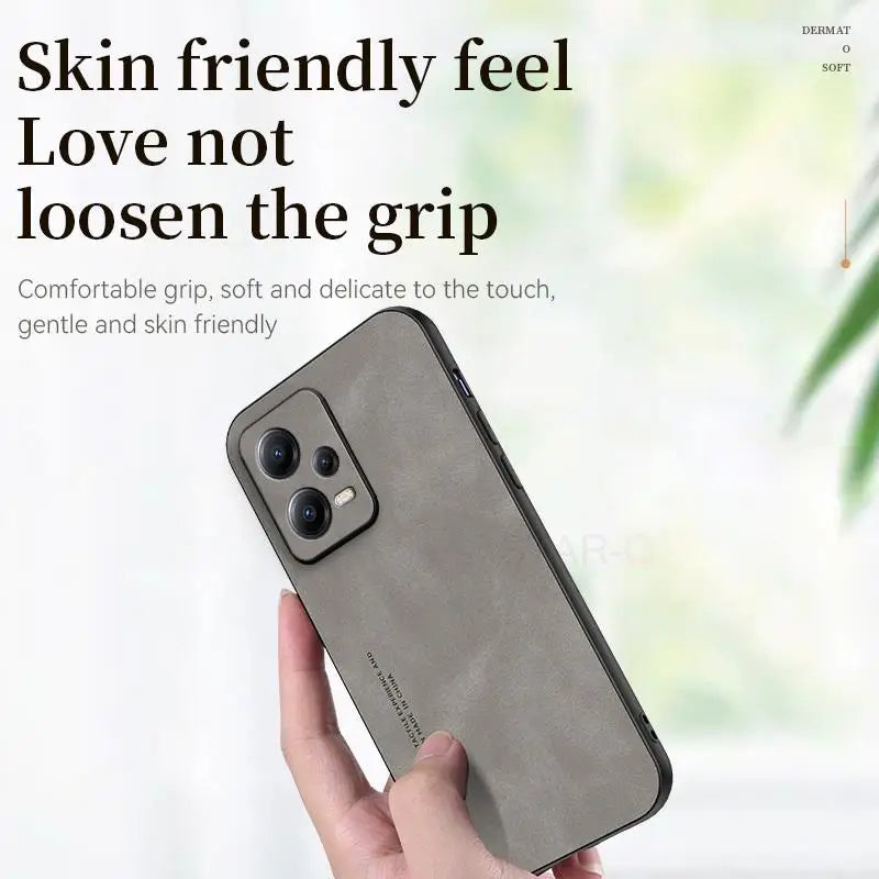 the back of a woman’s hand holding a gray iphone case