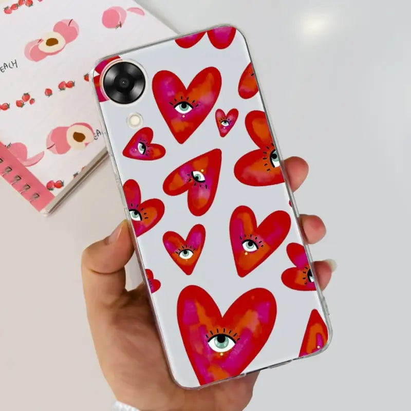 a hand holding a phone case with hearts on it