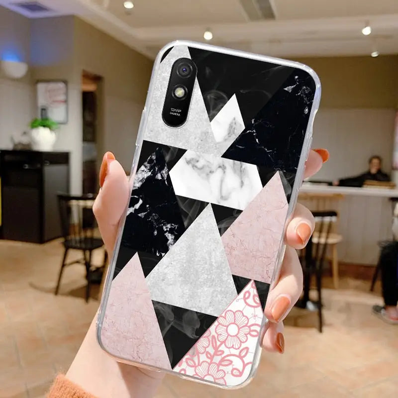 a woman holding up a phone case with a marble pattern