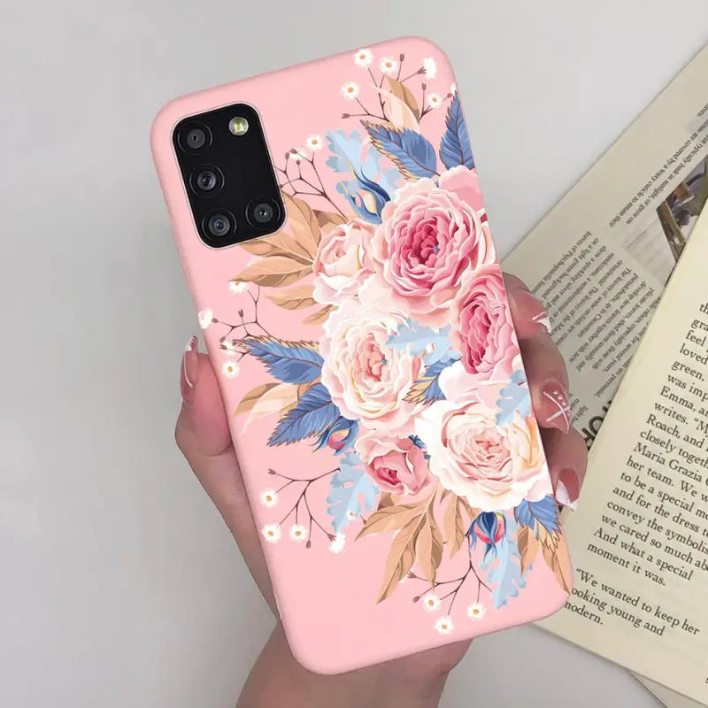 a woman holding a pink phone case with flowers on it