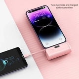 an iphone and a charging station on a pink background