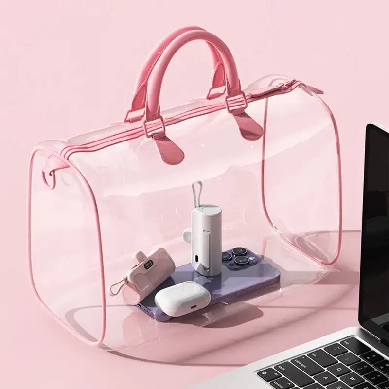 a laptop and a clear bag on a pink background