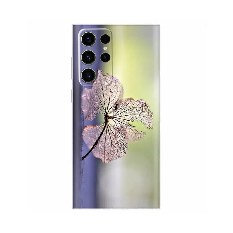 a close up of a leaf on a phone case with a blurry background