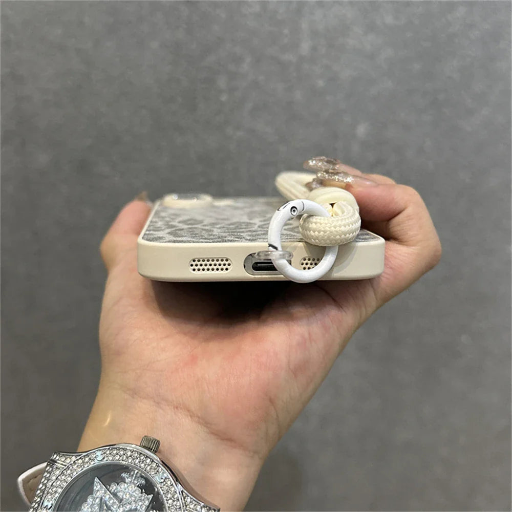 Leopard print phone case with wrist strap.