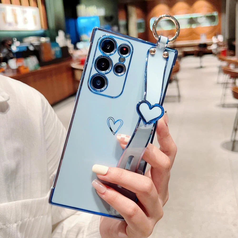 Light blue phone case with a heart design and a wrist strap.