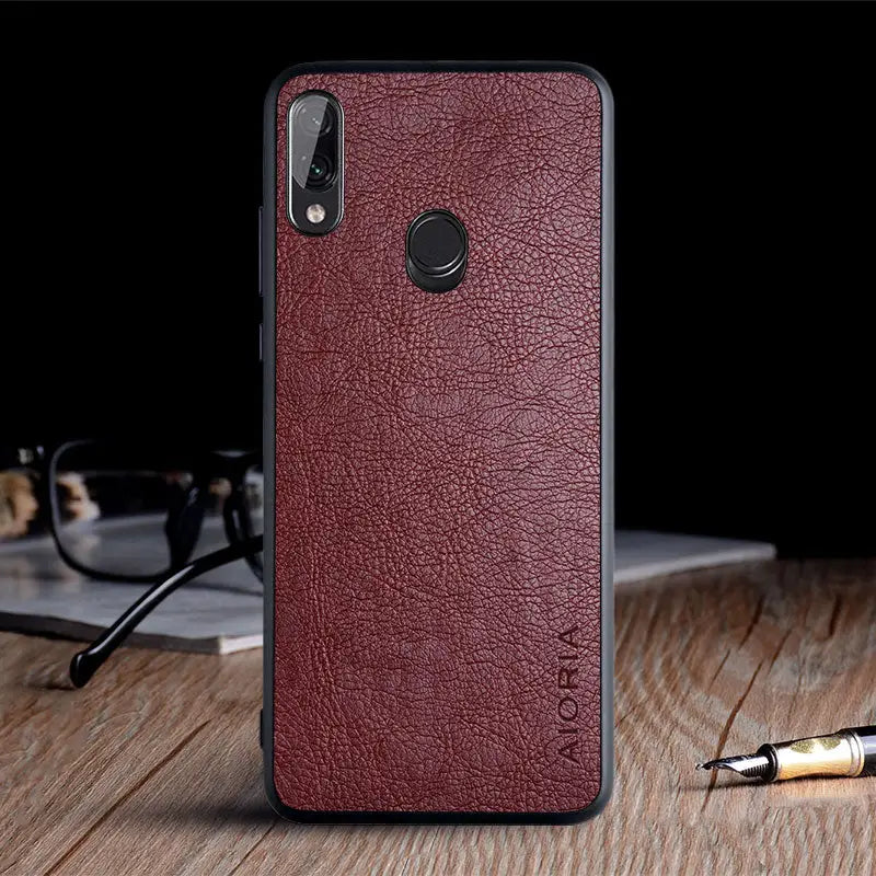 the back of a red leather case with a pen and glasses